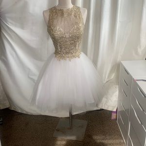 This prom dress has a gold lace top with rhinestones and a sheer top.
